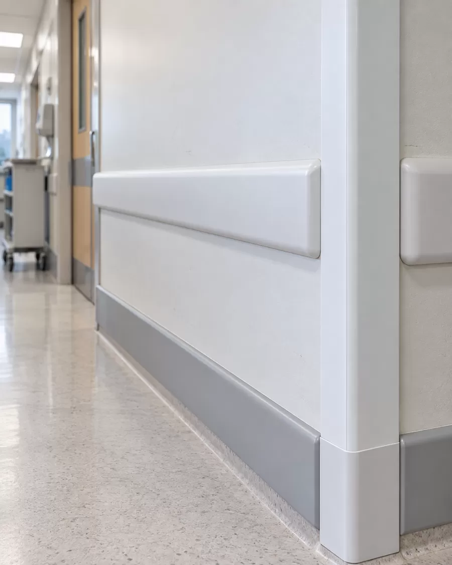 Detalhe da faixa protetora de parede em PVC branco instalado na parede de um corredor hospitalar